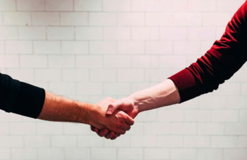 two-person-shaking-hands-near-white-painted-wall.jpg two person shaking hands near white painted wall